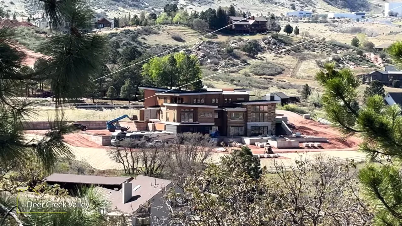 Aerial view of a Deer Creek Valley custom home with surrounding mountain landscape