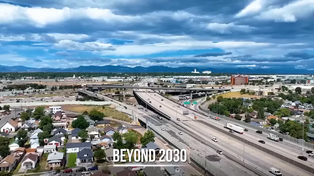 Aerial view of Denver freeway and surrounding neighborhoods with large development signage reading “BEYOND 2030”