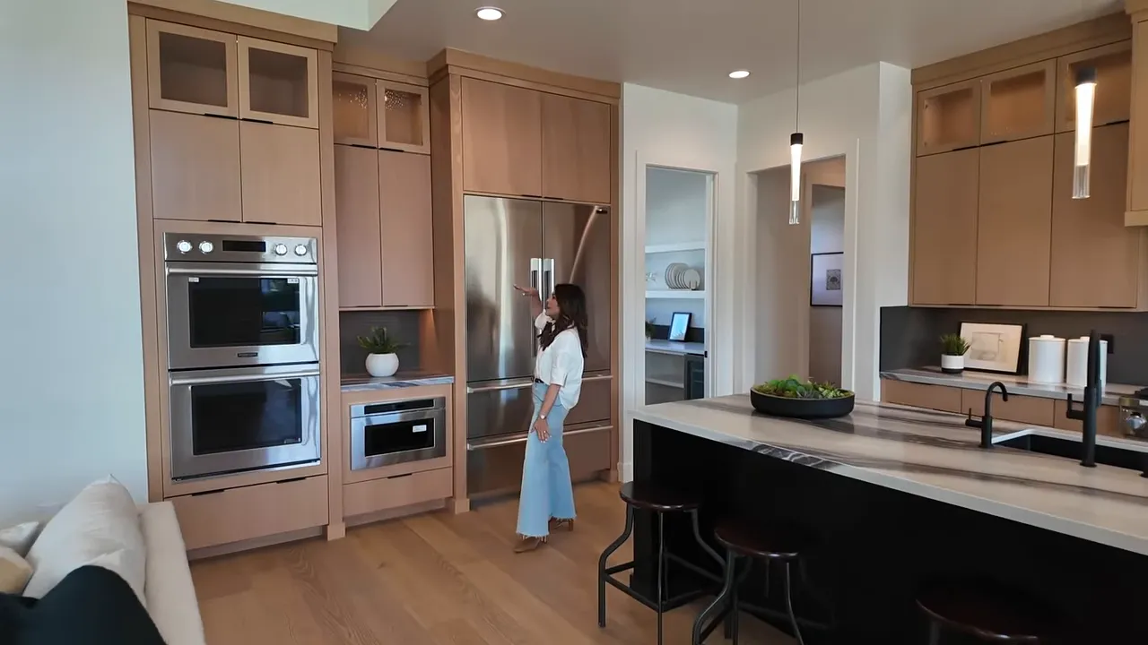 Kitchen view highlighting double ovens, custom cabinetry, and a statement range hood