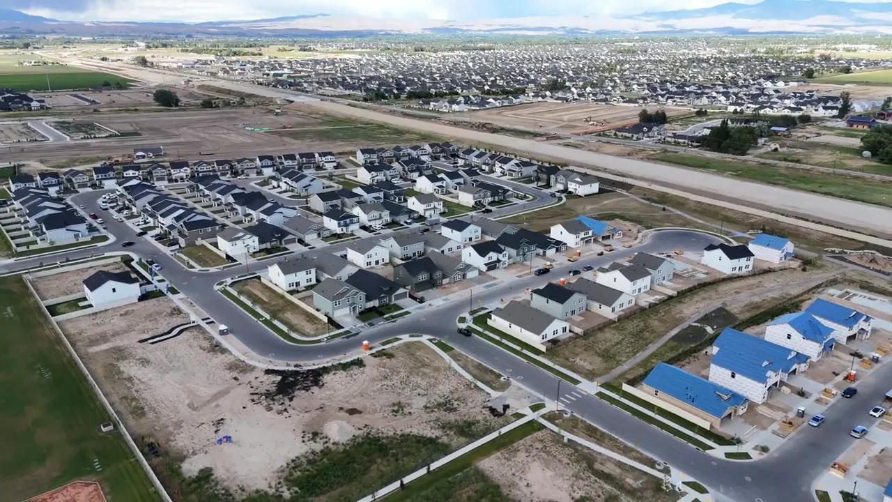 High-resolution aerial drone image of a new housing subdivision and nearby construction sites in Idaho.