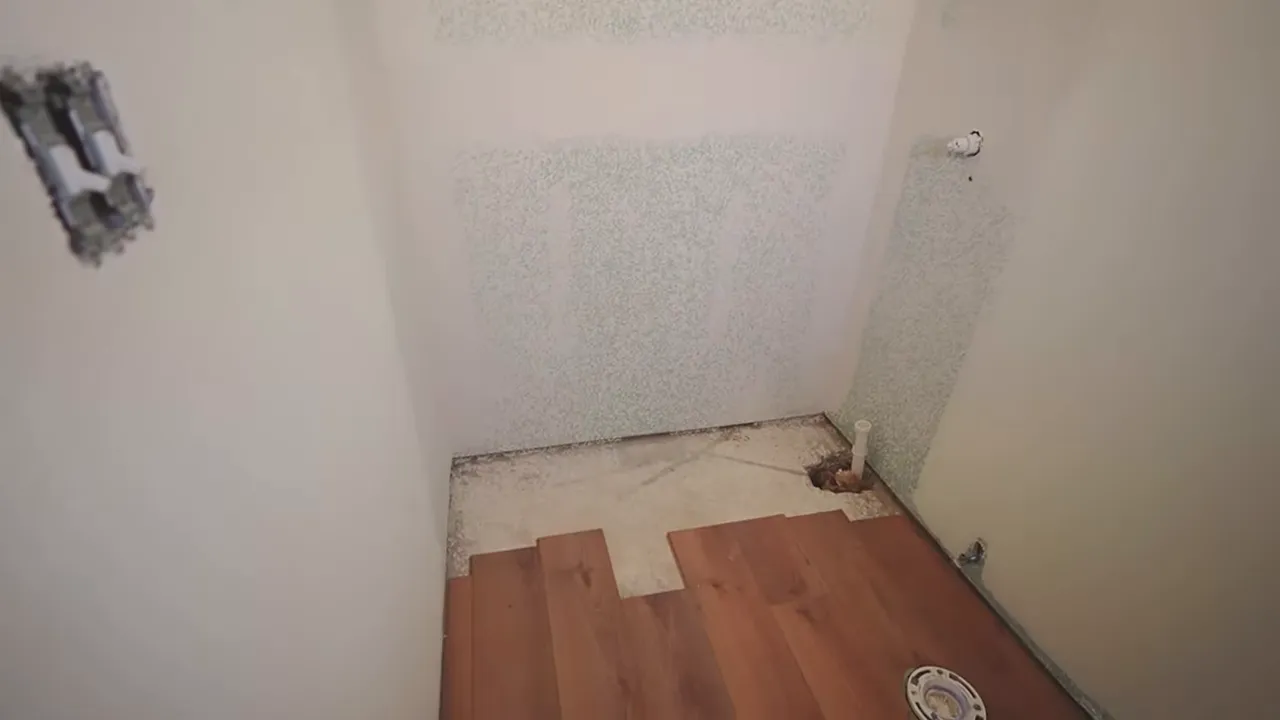 Small unfinished bathroom or utility space with partial flooring and exposed plumbing openings