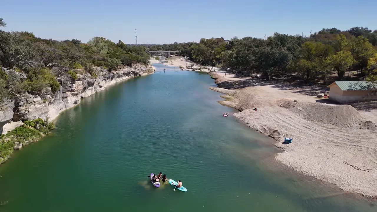 Aerial view of a Georgetown, Texas riverfront with kayakers and a landscaped shoreline