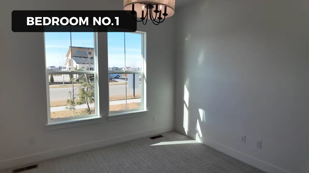 Bedroom No. 1 in a luxury Eagle Idaho home with large windows and carpeted flooring