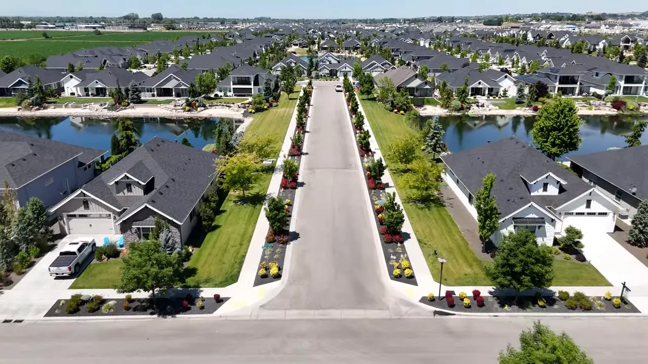 Long straight neighborhood street lined with homes lakes and landscaping