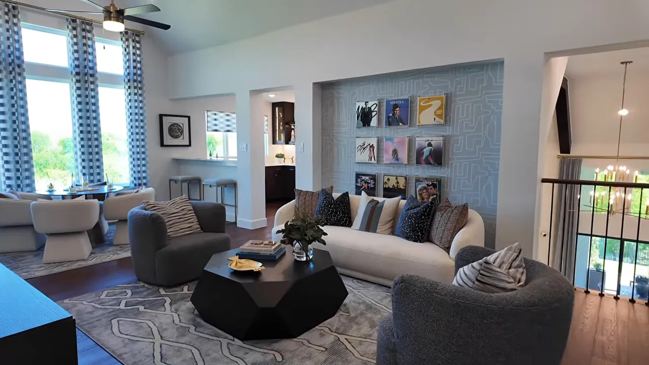 Spacious upstairs game room seating area with sectional couches and decorative wall display
