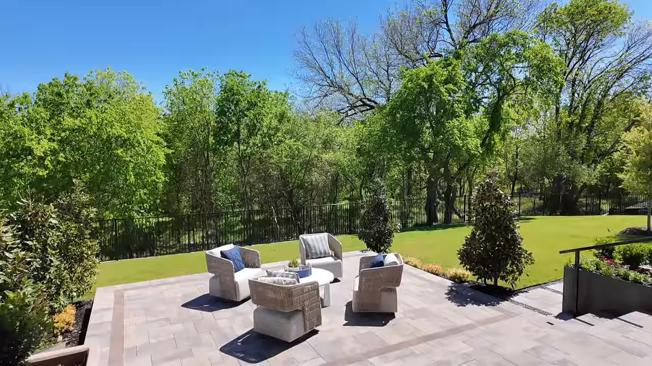Outdoor living patio with seating overlooking a large green backyard at Estates at Bristol Valley in Heath TX