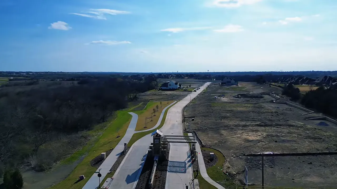 Aerial view of a residential community near Heath, Texas with open lots and winding roads