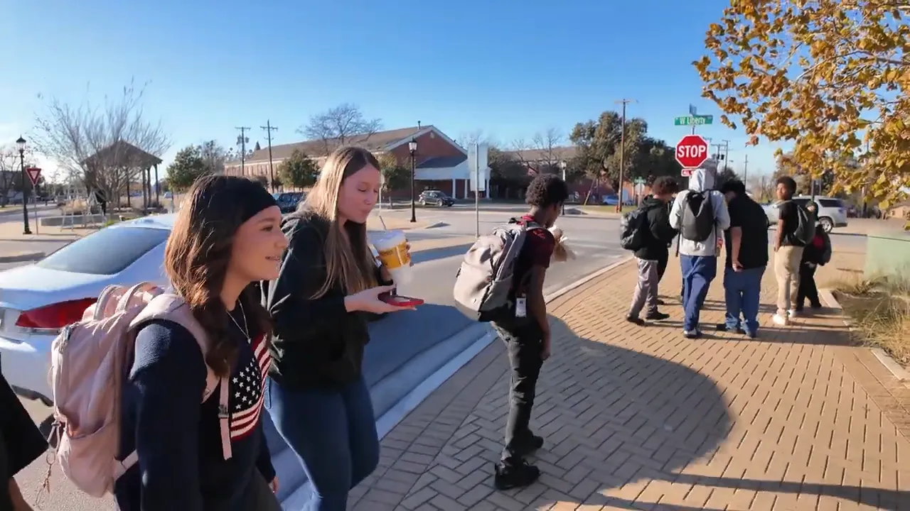 Group of people walking together near a Round Rock stop sign