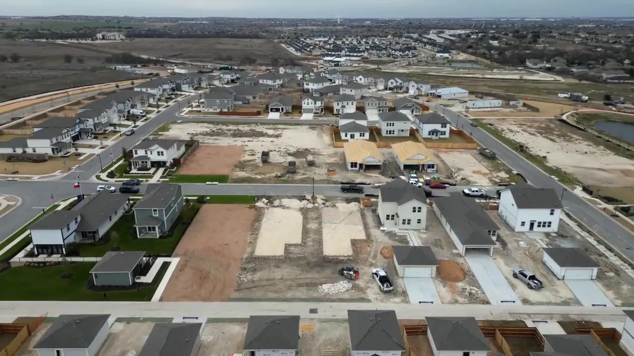 Aerial view of large Round Rock master-planned neighborhood with many houses and internal roads