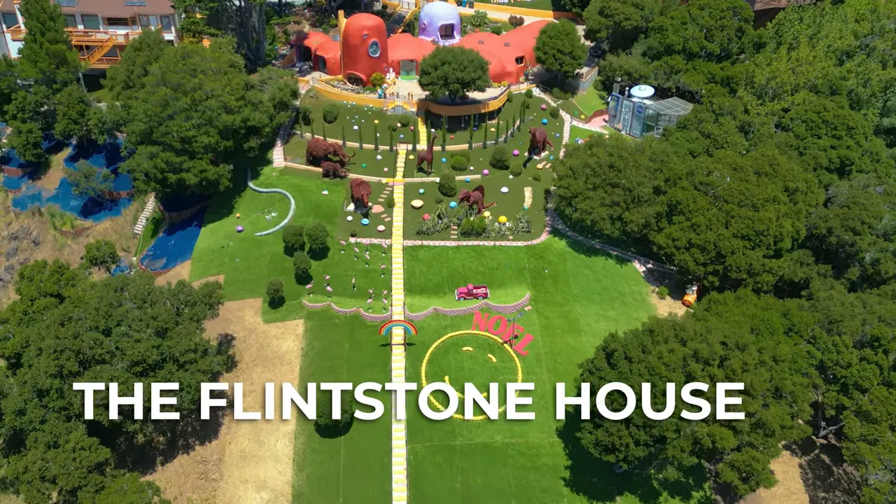 Aerial view of the Flintstone House property with bright lawn and paths