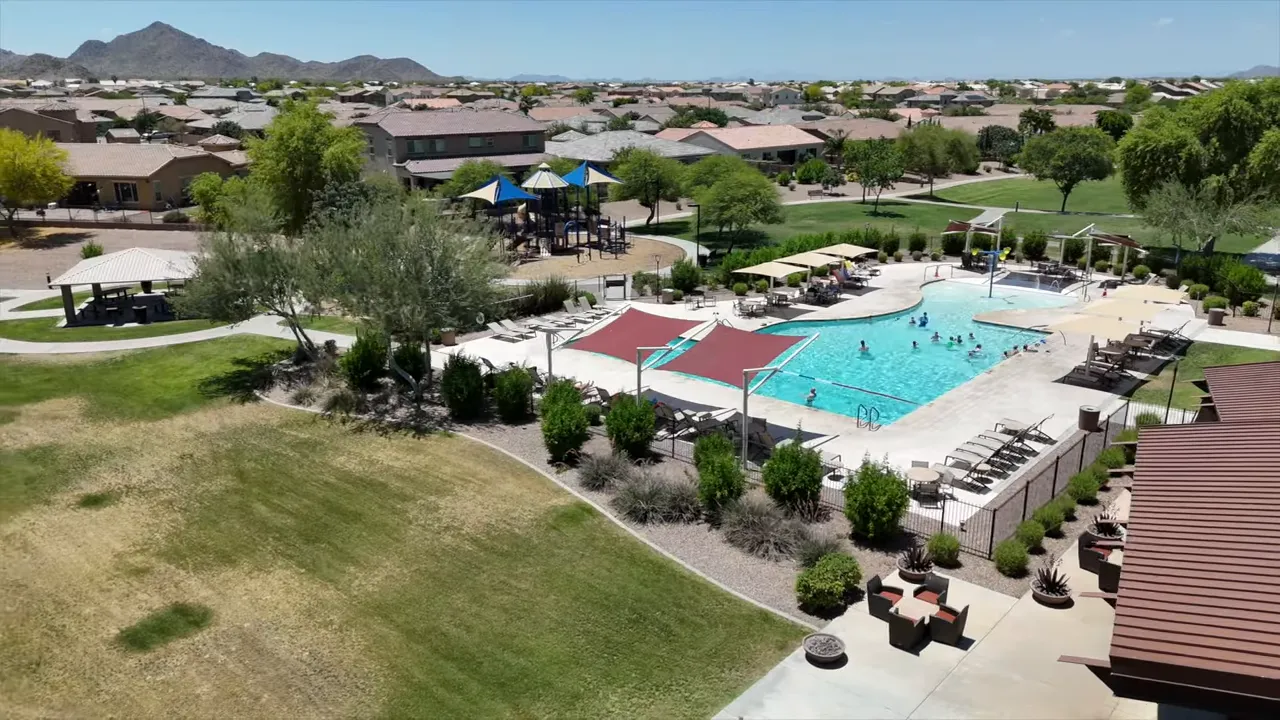 aerial view of community pool tennis courts and nearby playground area