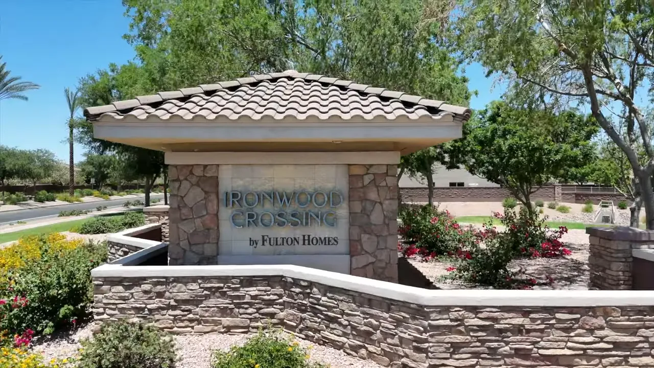 stone entrance monument for Ironwood Crossing with green trees behind it