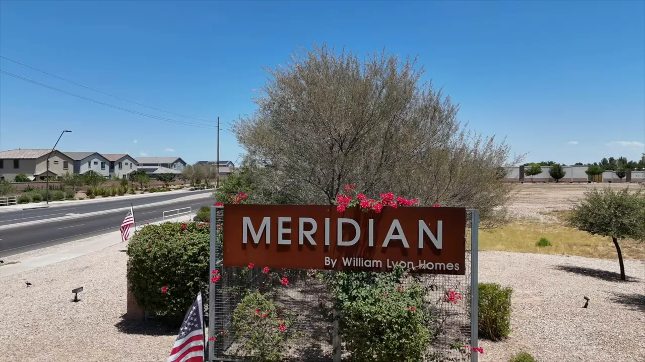 Meridian neighborhood entrance sign beside a roadway and desert landscaping
