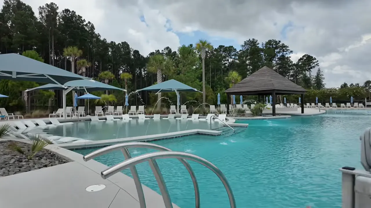 Resort-style pool area with umbrellas and cabana seating