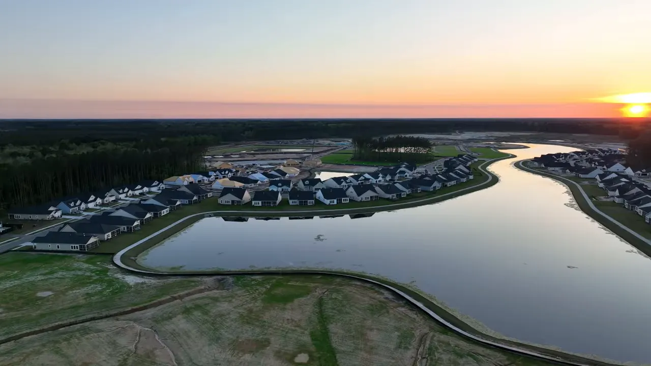 Aerial view of homes and a winding waterway in Cane Bay master-planned community at sunset