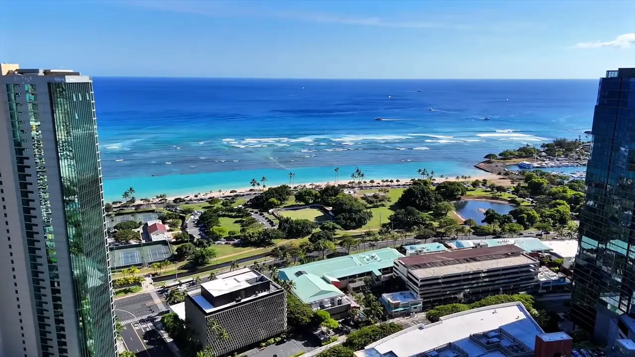 Aerial view of Kaka‘ako Honolulu with oceanfront coastline, marina, and high-rise buildings