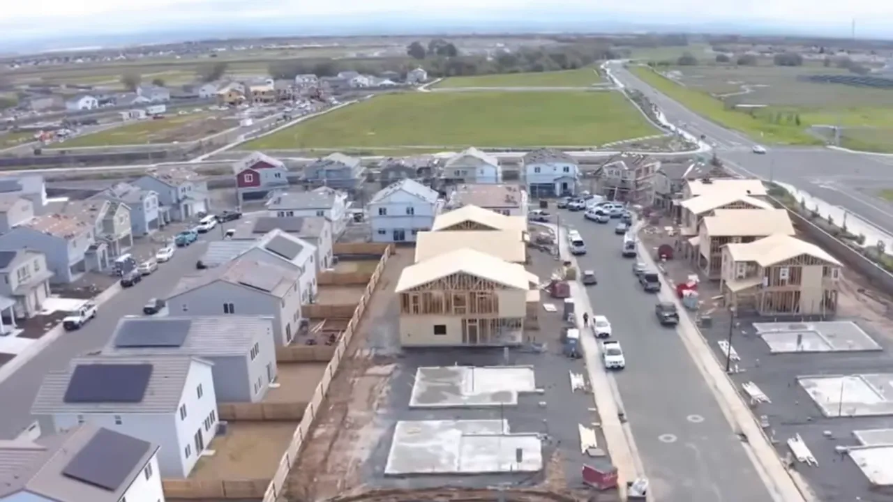 Drone view of new housing construction and lots in a developing suburban neighborhood.