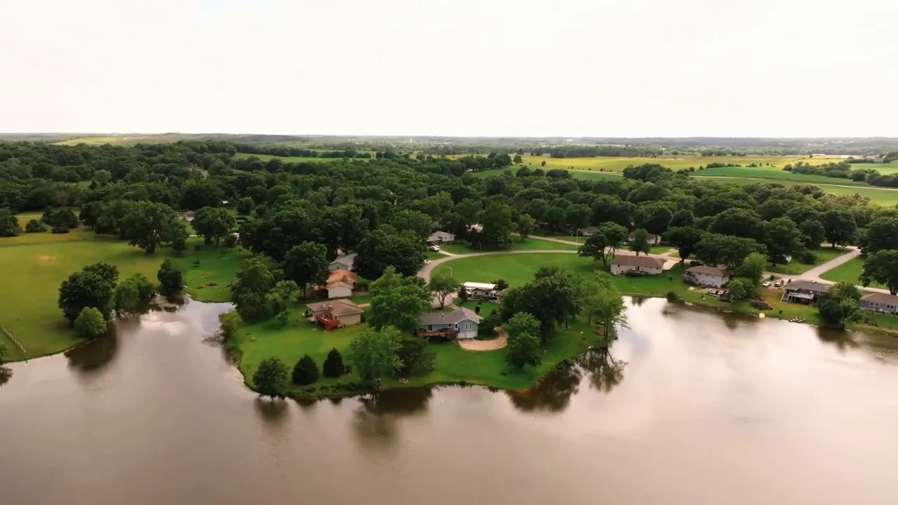 Aerial view of homes along a lake surrounded by trees