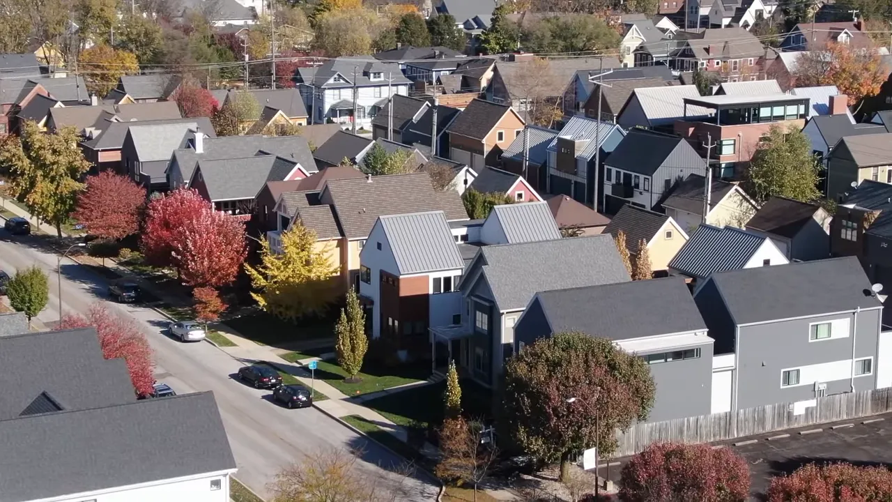Aerial view of tightly spaced, varied homes and tree-lined streets in a residential neighborhood