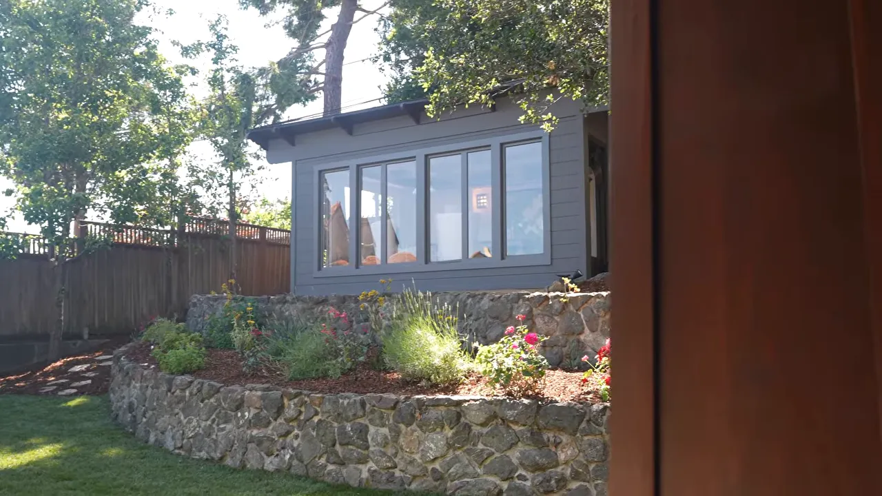Detached studio building with windows and yard around it