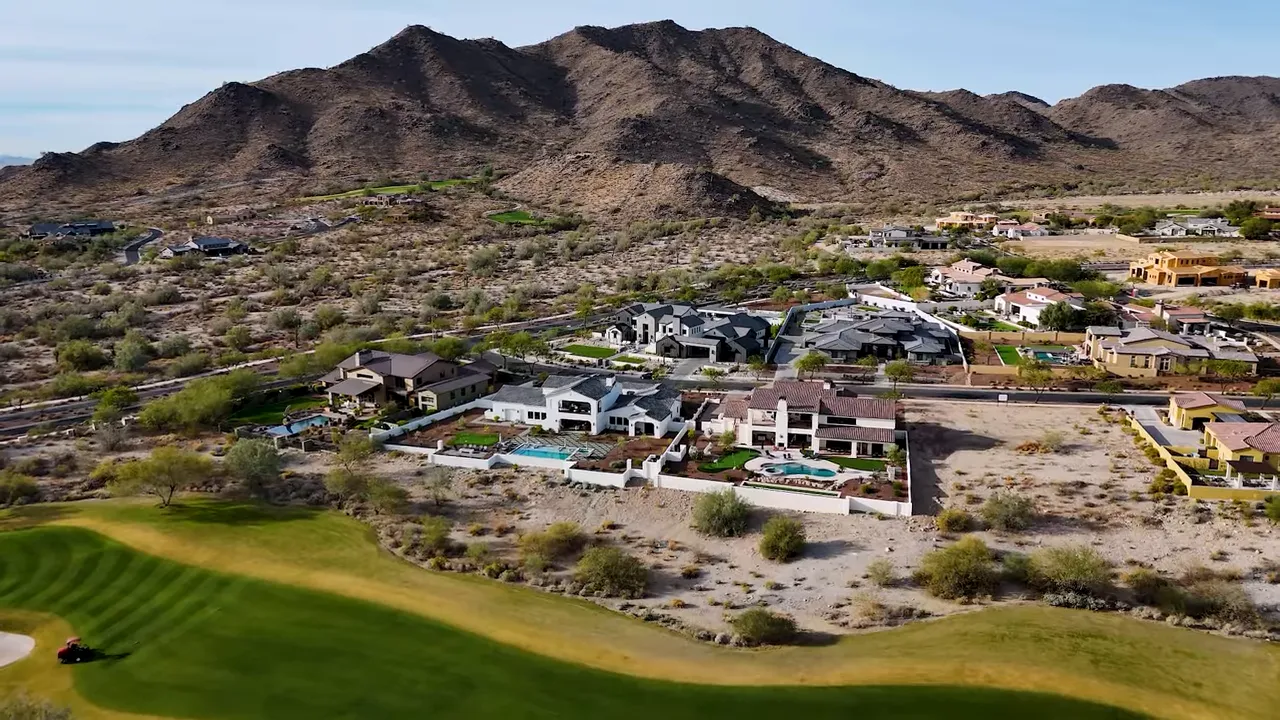 Aerial view of luxury homes in a desert community with mountains in the background