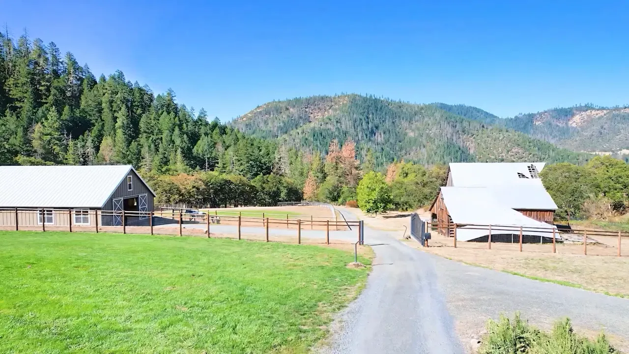 Rural Southern Oregon property with pasture, barns, and forested hills