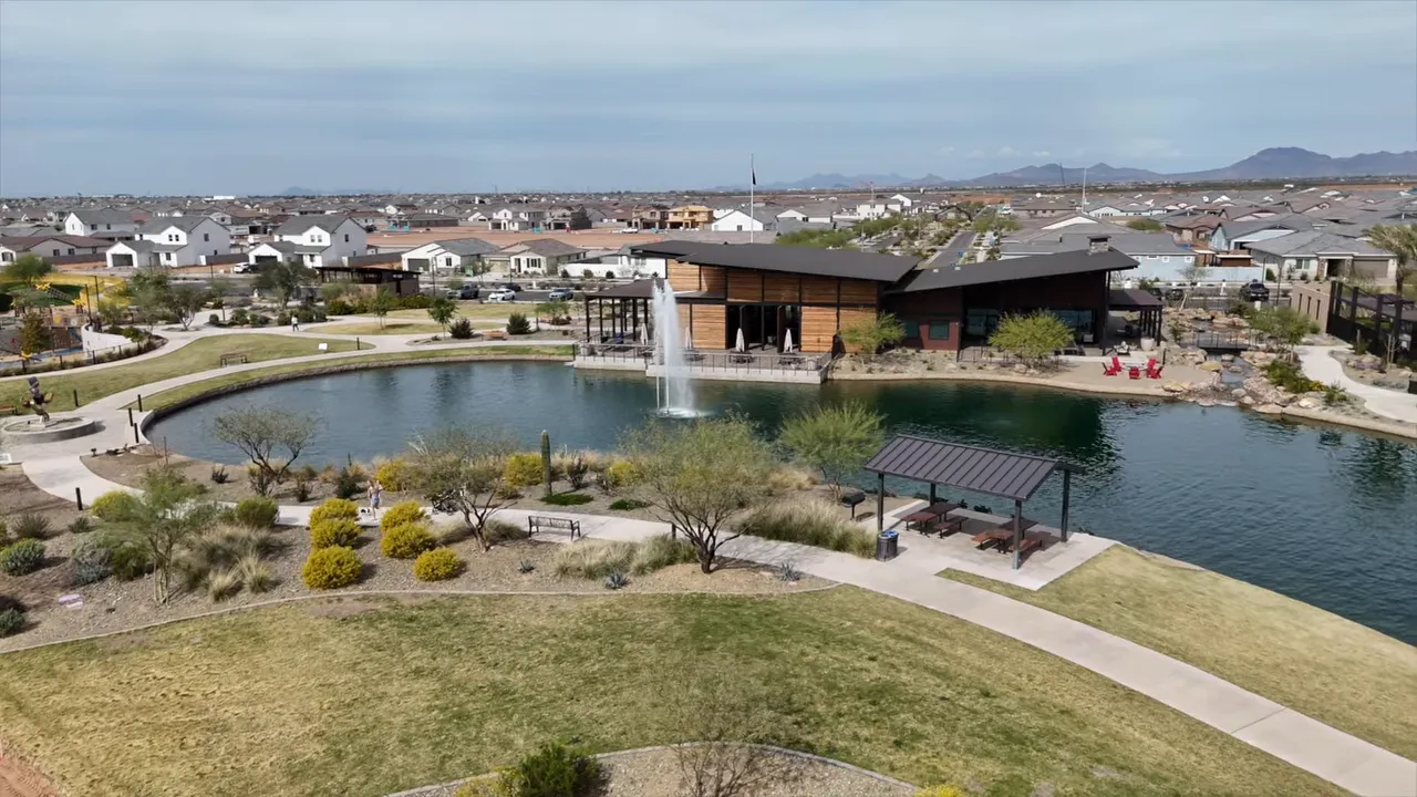 Lake with fountain walking paths clubhouse and surrounding homes at Blossom Rock