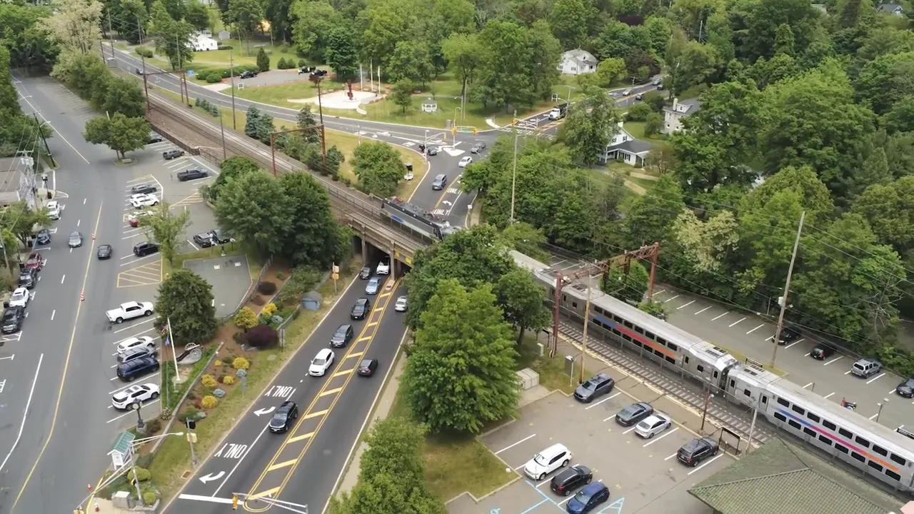 Aerial view of a New Jersey rail line near a road junction and parking lot