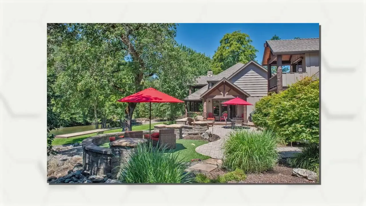 Landscaped estate patio with red umbrellas and water feature