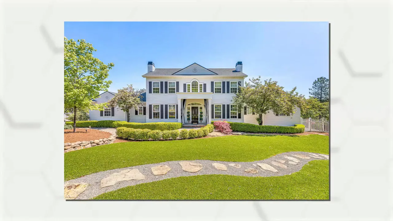 Large white estate with swimming pool and landscaped grounds