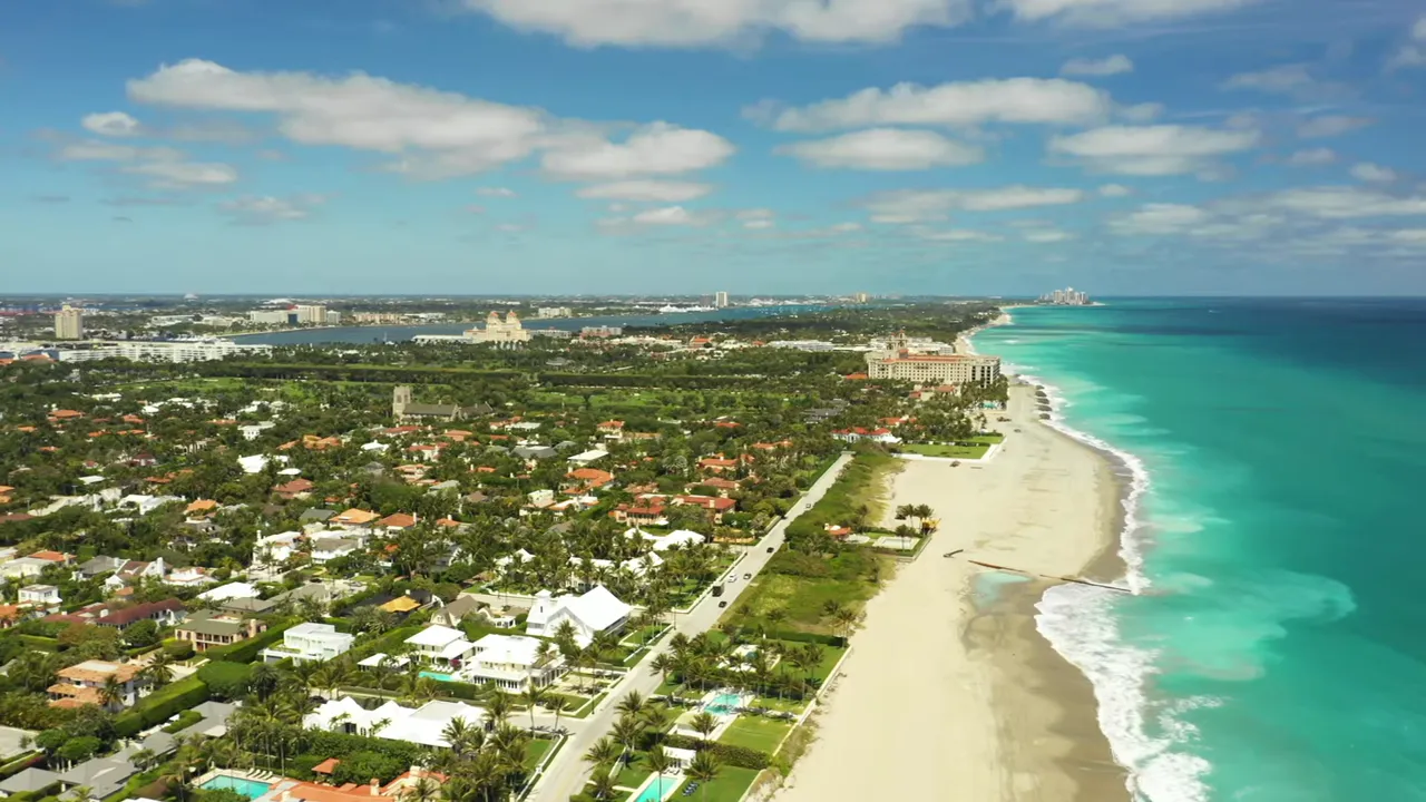 Aerial coastline view of West Palm Beach showing the beach, turquoise Atlantic water, and beachfront homes