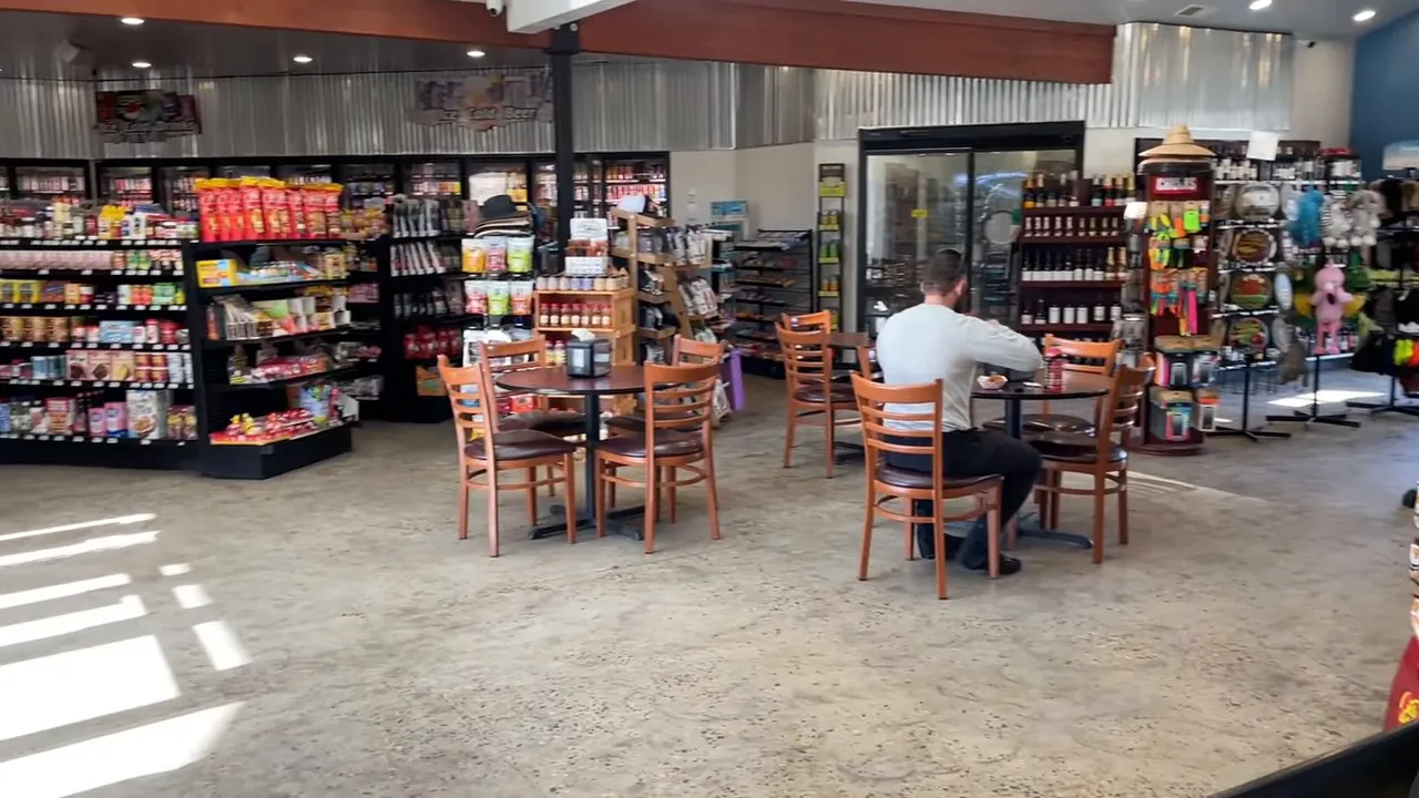 Avimor community coffee shop seating area with tables, displays, and a person dining