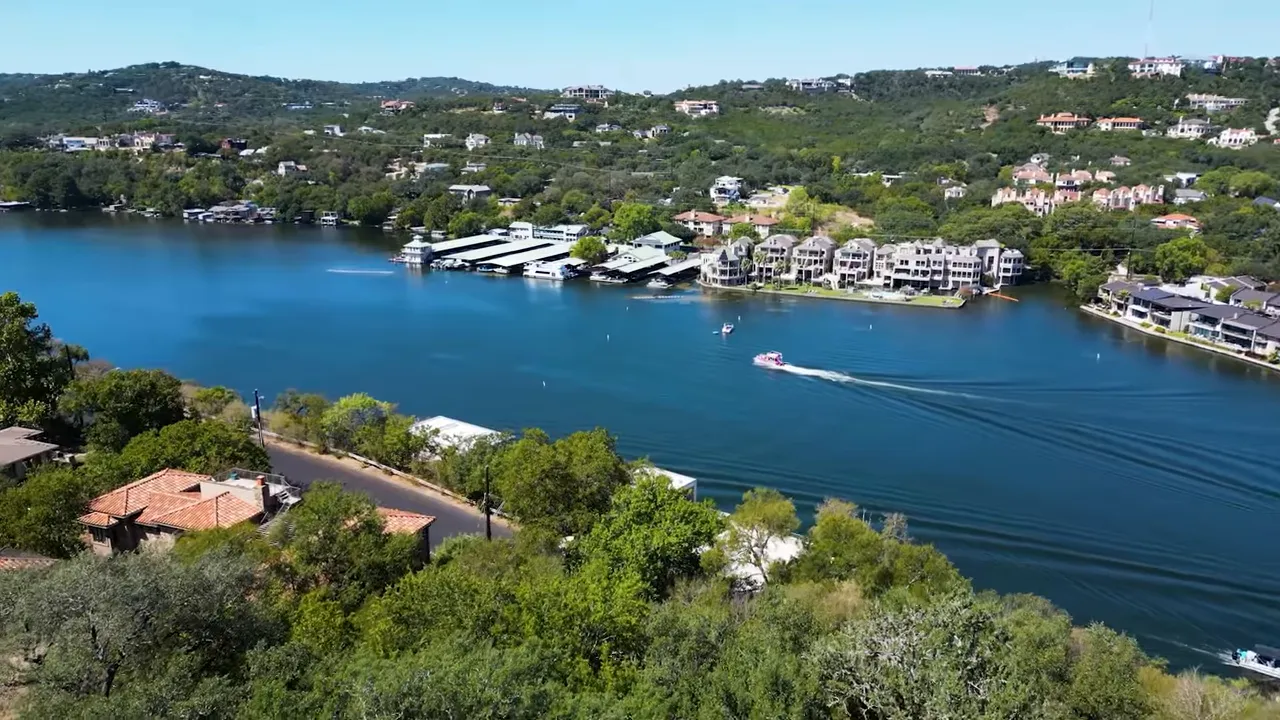 Aerial panorama of a West Austin lake with marinas, boats, and hillside homes