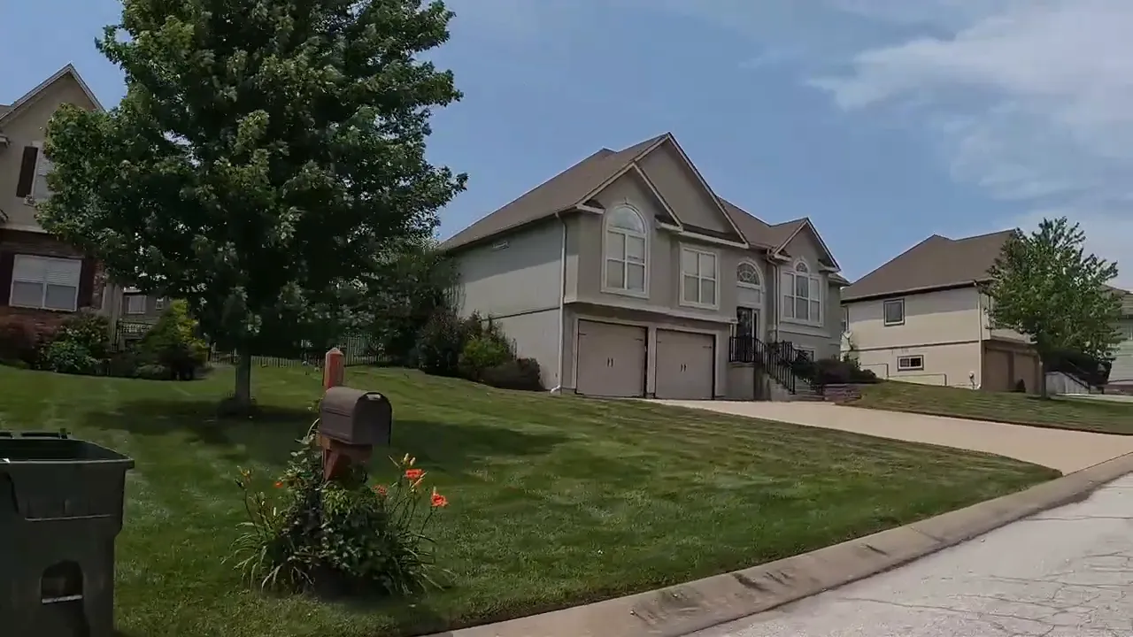 Cayhill neighborhood home with well-kept lawn and limited tree canopy in Warrensburg, Missouri