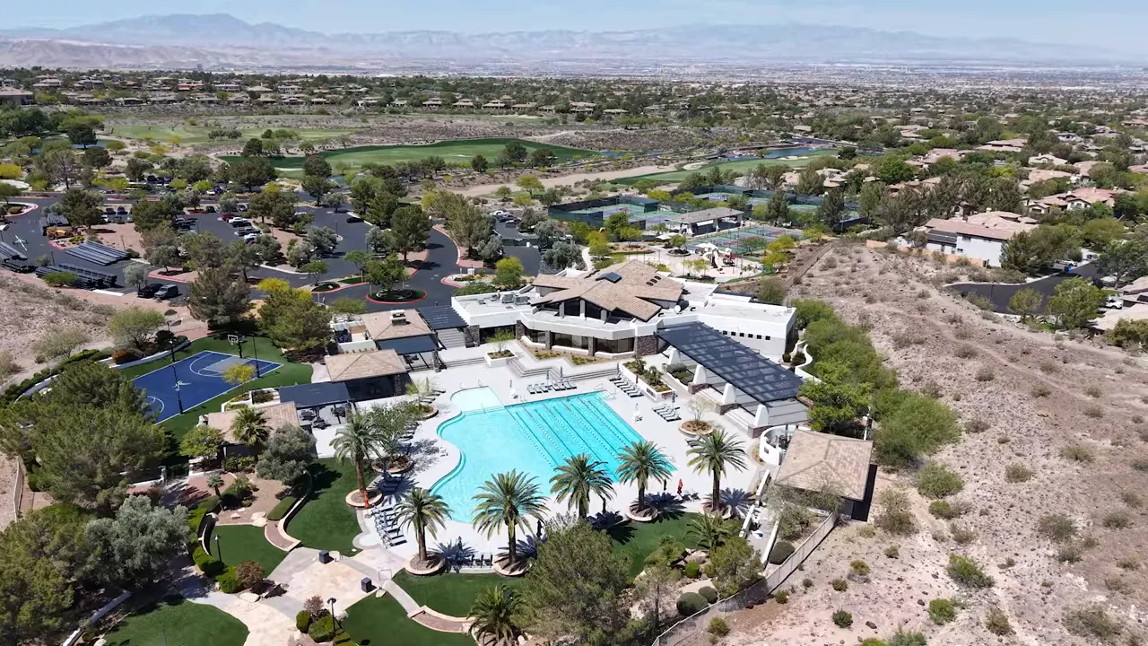 Aerial view of the resort swimming pool surrounded by clubhouse buildings and desert hills