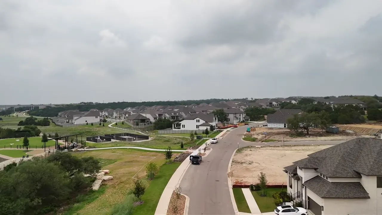 Aerial view of a planned residential community neighborhood roads and homes near green space in Georgetown Texas suburbs