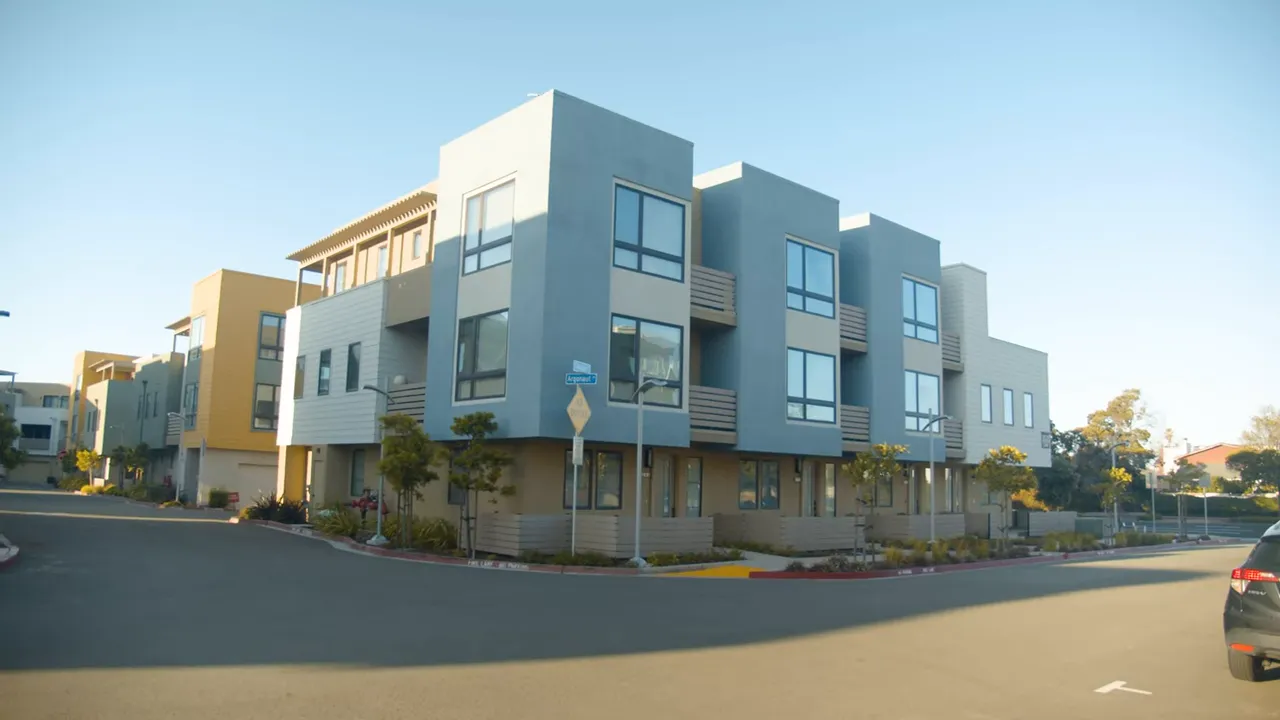 Modern townhome-style residential building on a corner in a suburban neighborhood
