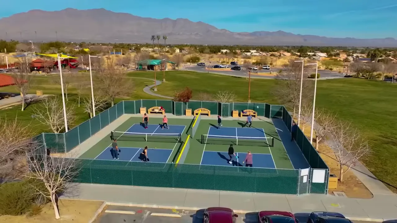 Overhead view of multiple outdoor pickleball courts with players