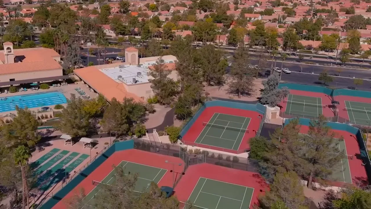 Aerial view of recreation facilities with tennis courts and swimming pool in a residential community