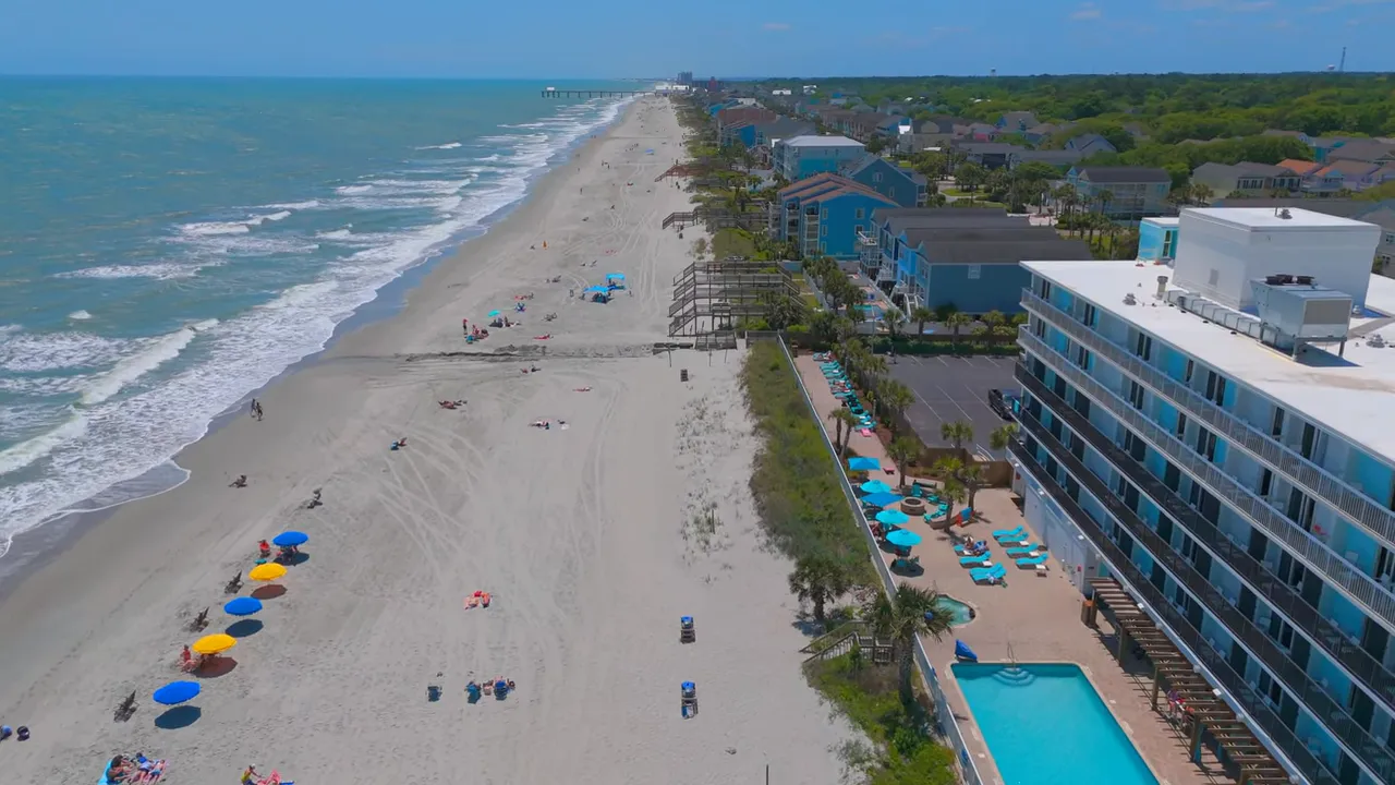 Aerial view of Surfside Beach oceanfront beach and beachfront hotel with pool