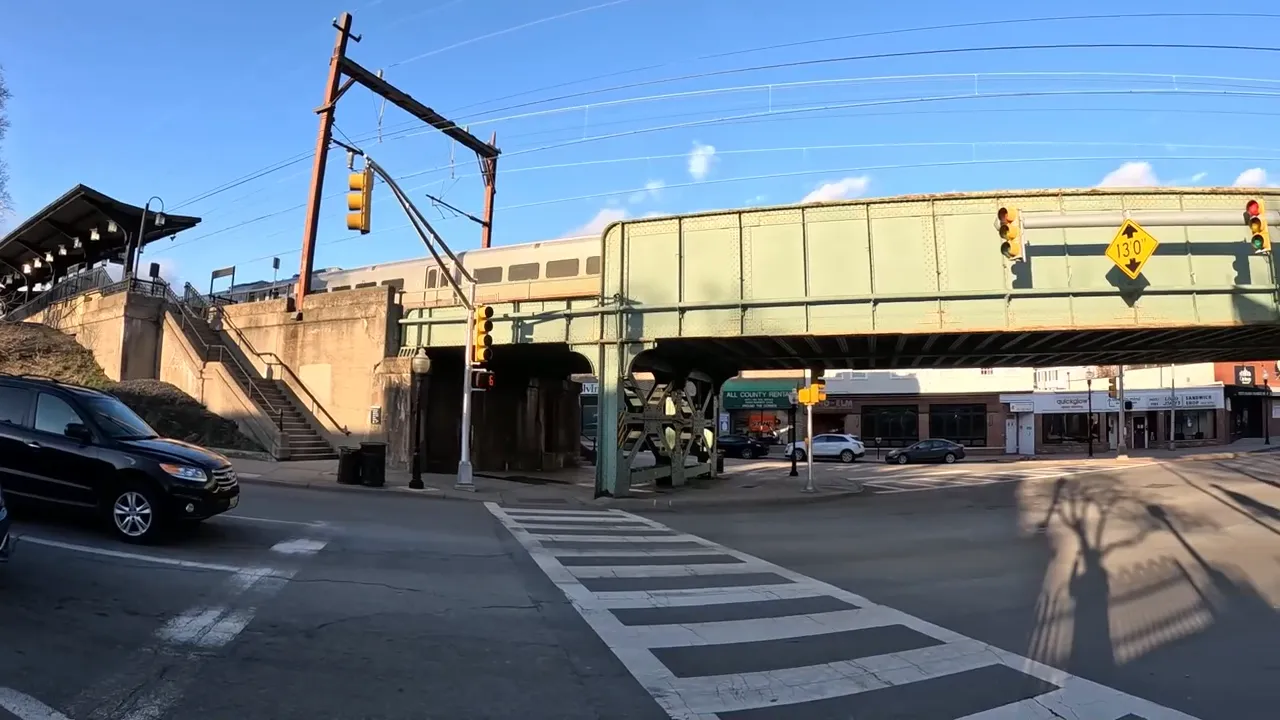 View of train tracks and station platform area in Morristown at a street crossing