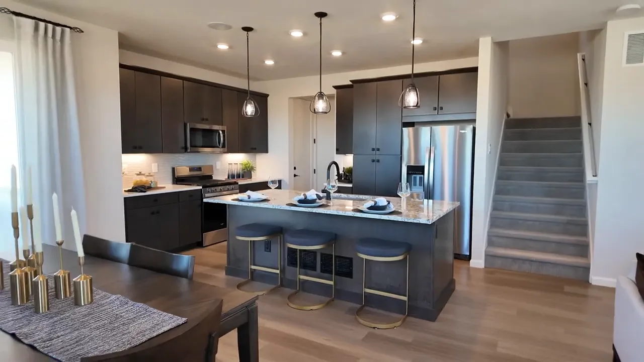 Kitchen island overlooking living space with modern dark cabinetry in Tri Pointe Aurora Highlands home