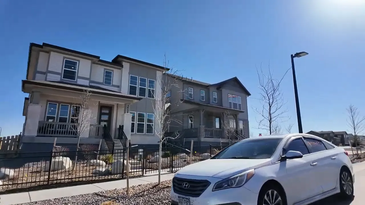 Exterior view of new construction homes and a parked car at Aurora Highlands in Aurora, Colorado