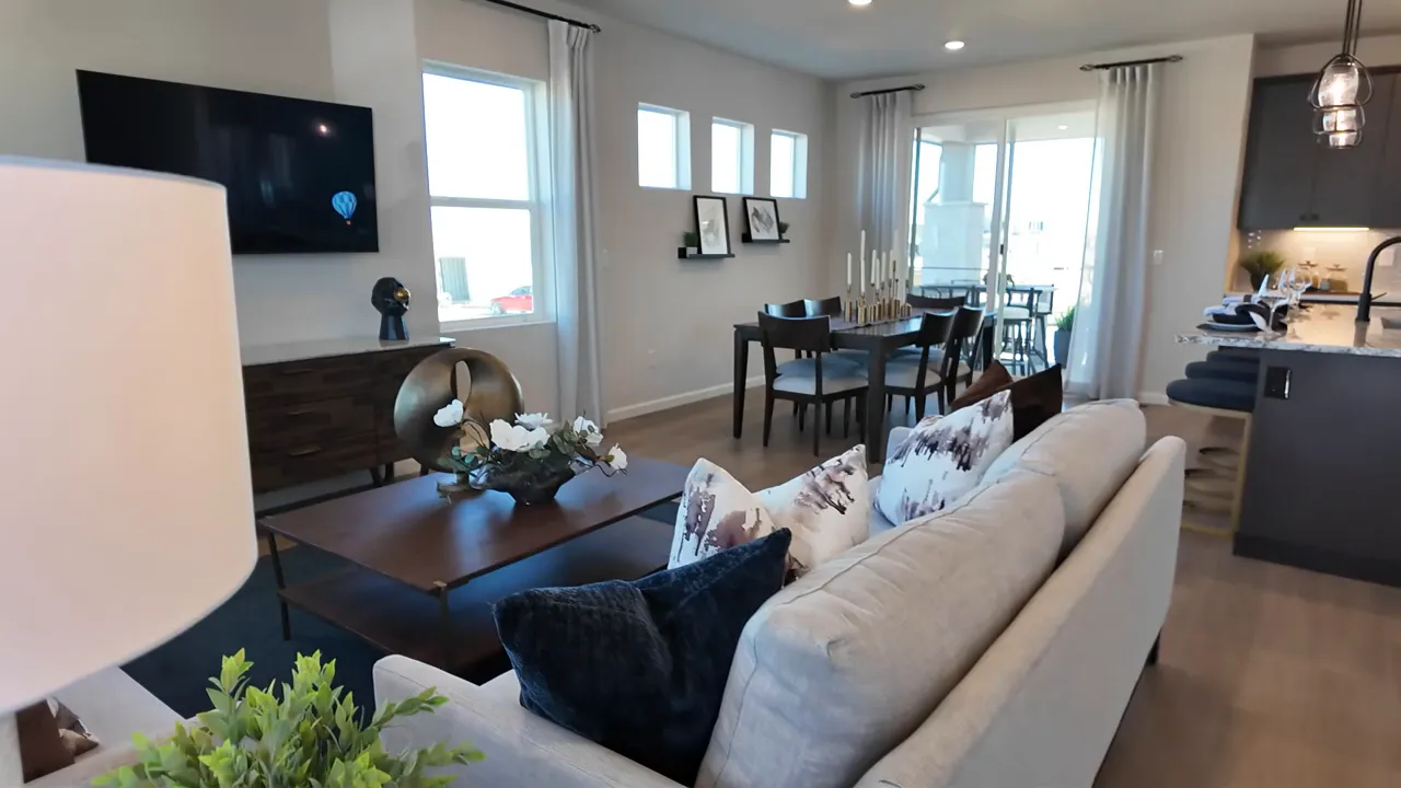 Tri Pointe Aurora Highlands larger home open living room with sofa and dining area