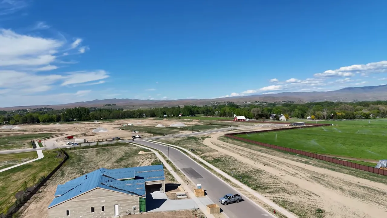 Aerial view of Eagle, Idaho neighborhood with winding roads, green fields, and mountain horizon