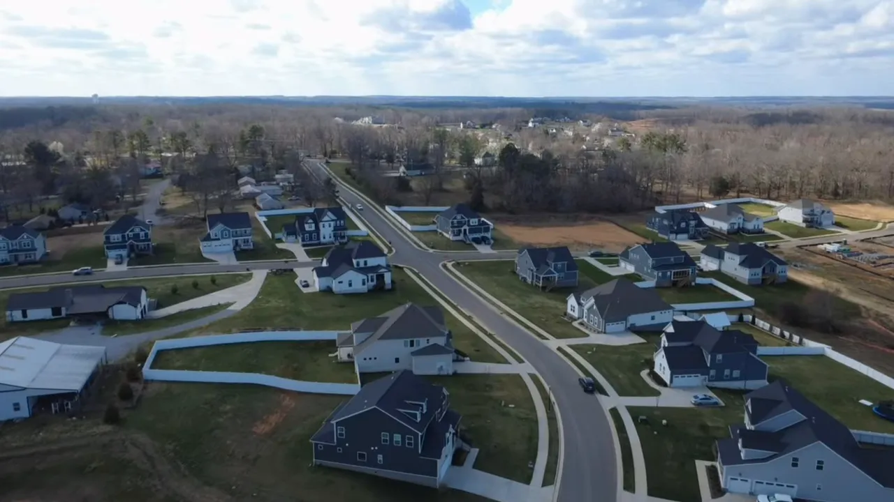 Aerial view of neighborhood streets homes and wooded surroundings