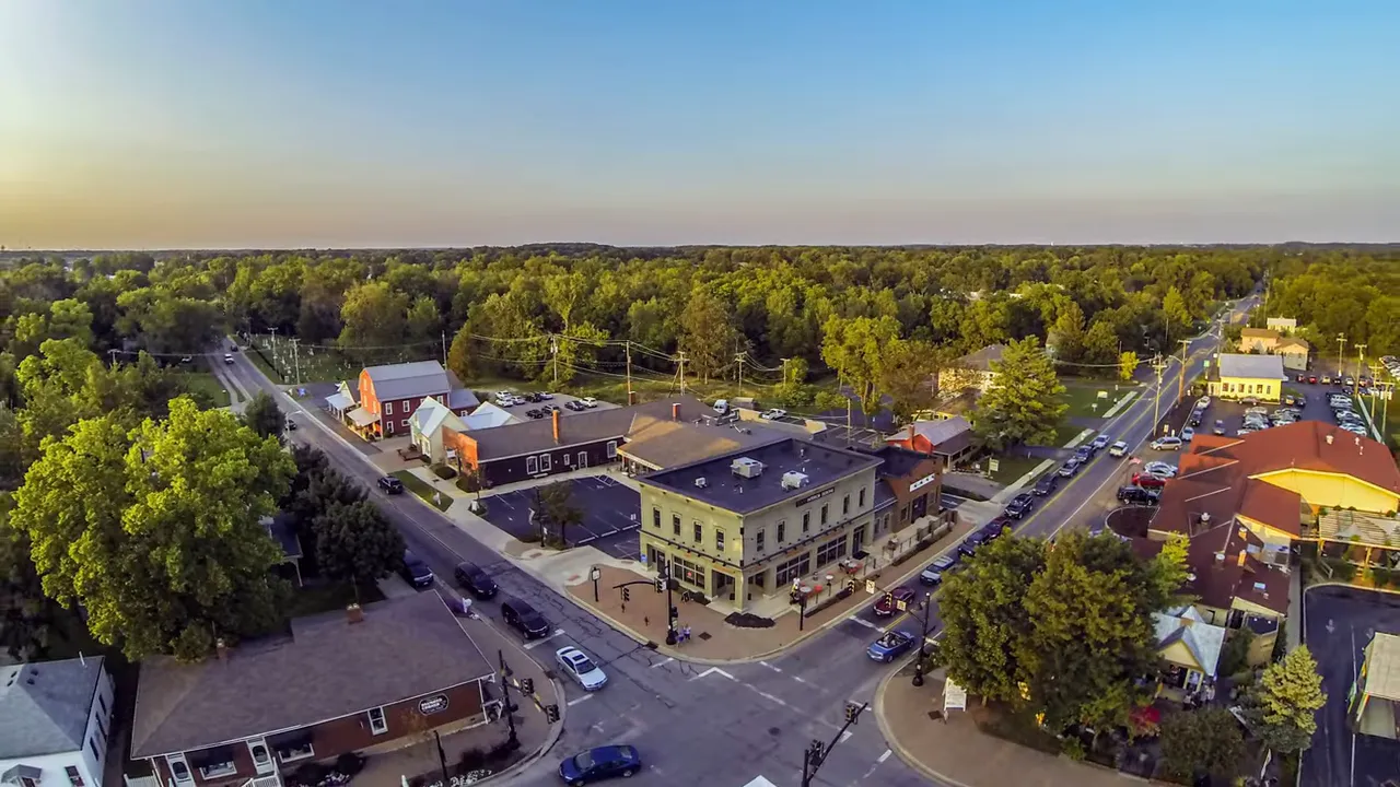 Aerial view of a small downtown intersection surrounded by trees and low rise buildings