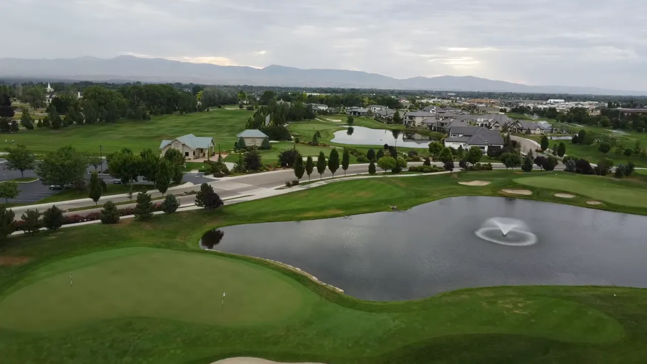 Aerial view of a master-planned community golf course with ponds, walking paths and homes in the background.