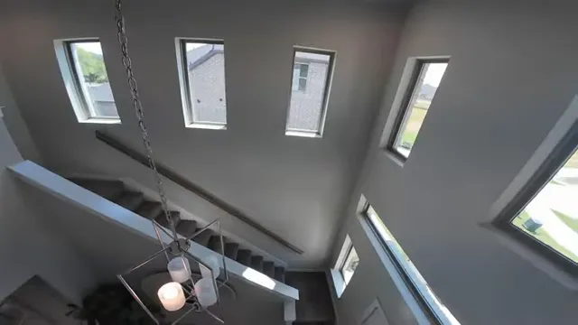 Tall stairwell with multiple narrow windows and hanging light fixture