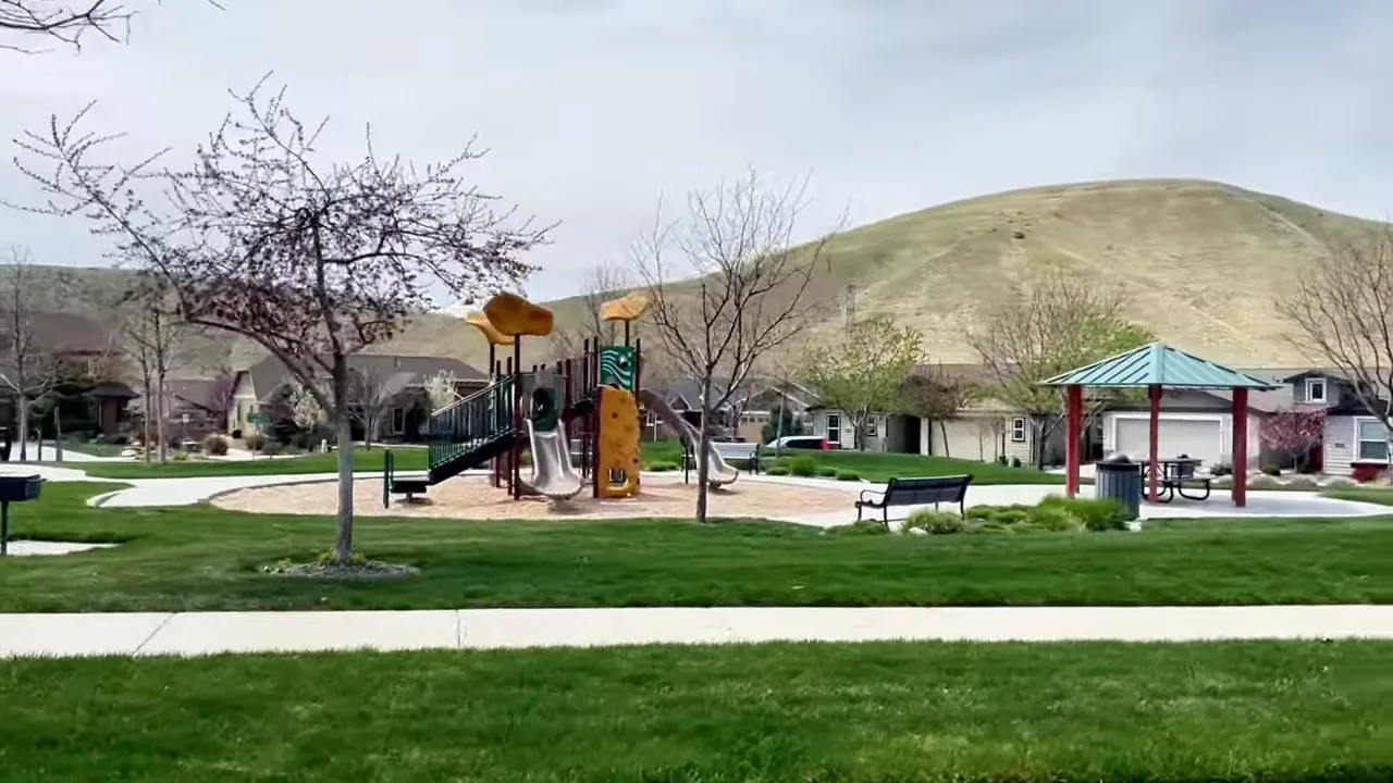 Playground, shaded pavilion and grassy park with homes and rolling foothills behind — a typical Avimor neighborhood green.